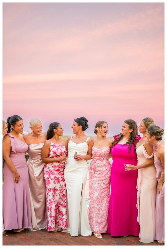Bride and bridesmaids with a pink sky outside Wychmere Beach Club