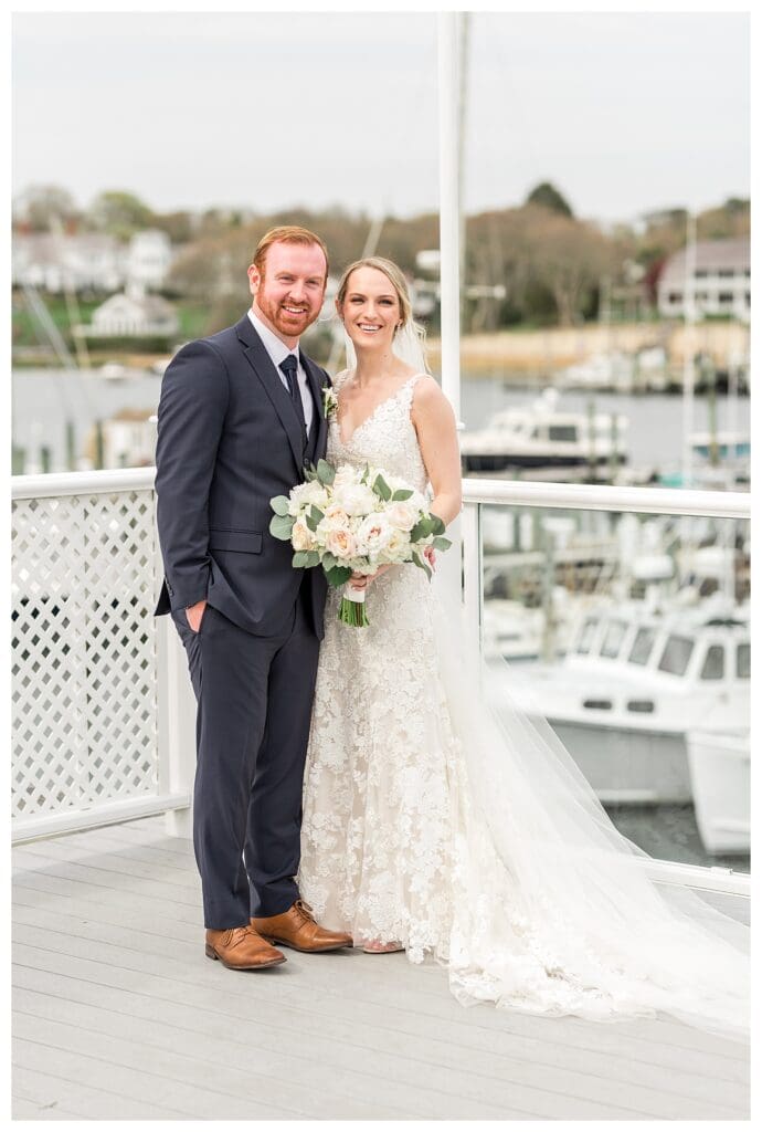 Couple standing together with anchored boats behind them at Wychmere