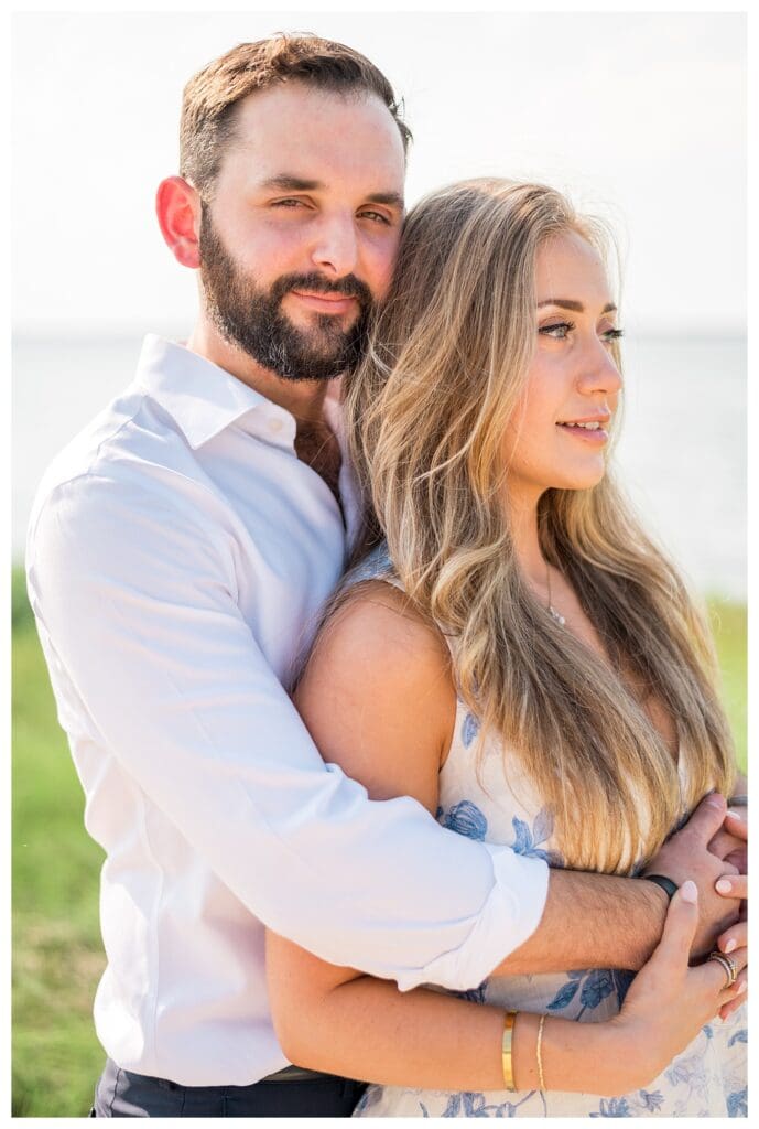 Intimate portrait of Reid and Libby embracing with coastal marsh views in Yarmouth, Cape Cod