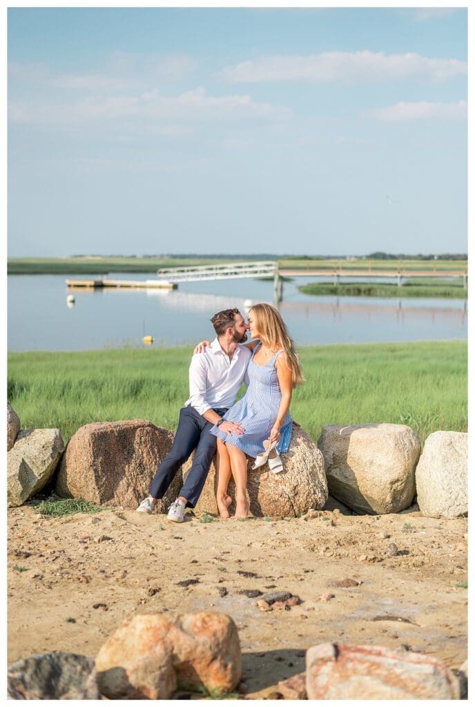 Reid and Libby standing together framed by coastal greenery in Yarmouth, Cape Cod