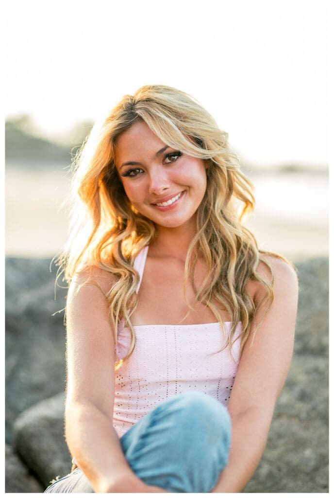 Smiling high school senior during a seaside photo session in Cohasset, Massachusetts