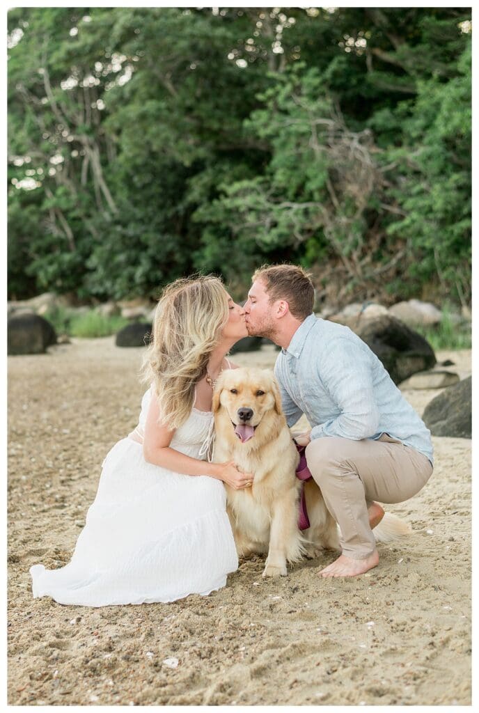 Jess and Jamie kissing over their golden retriever, Morgan, during their Cape Cod engagement session