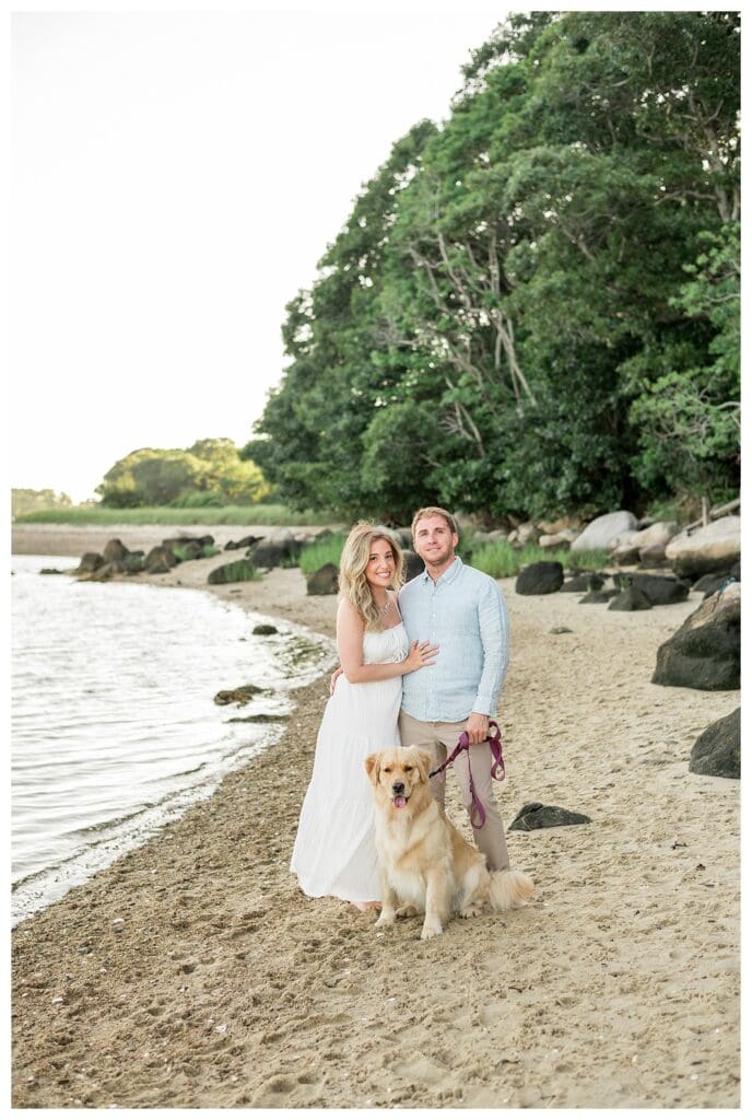Couple smiling with their golden retriever during engagement photos