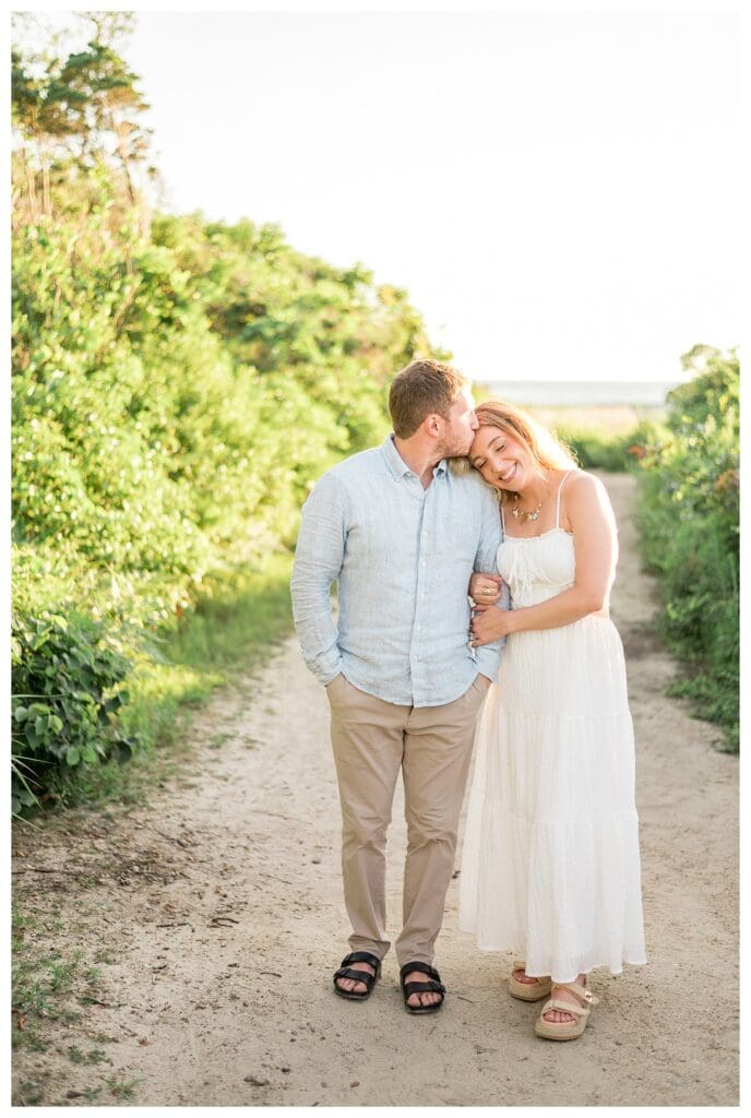 Couple sharing an intimate moment surrounded by greenery at The Knob in Falmouth, MA