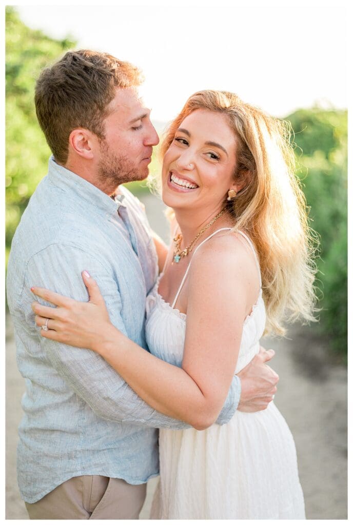 Joyful candid moment of Jess and Jamie laughing together on a sandy Cape Cod trail