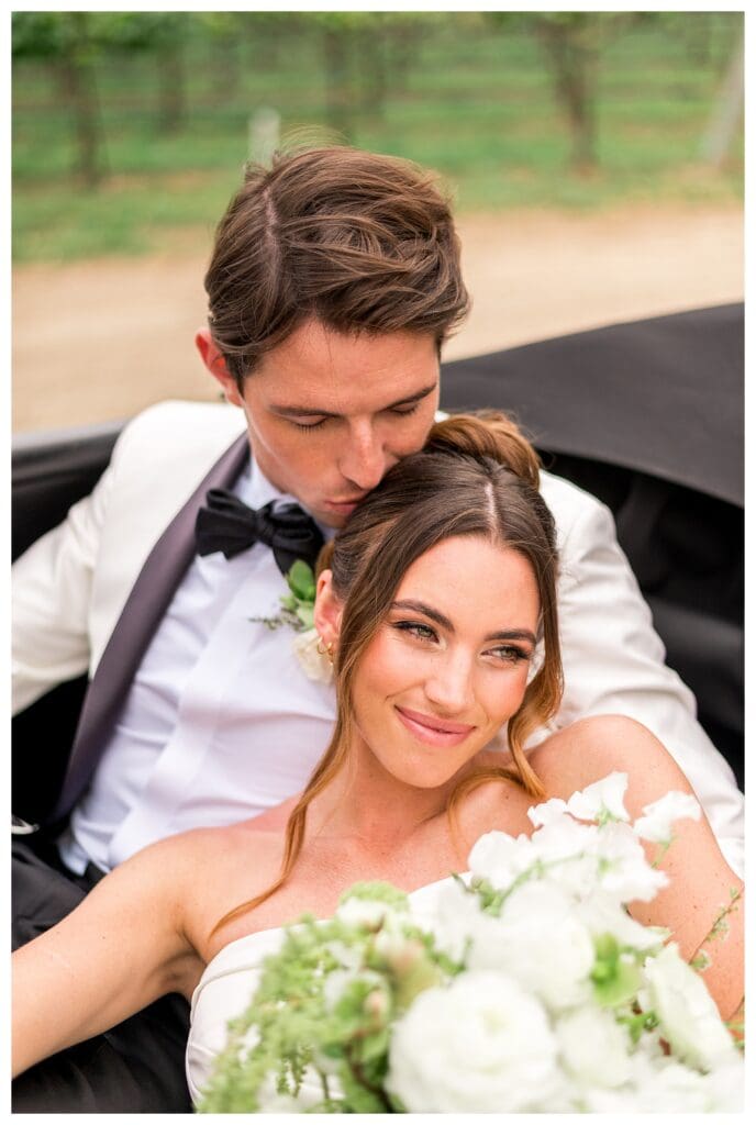 Bride and groom snuggled in a classic car