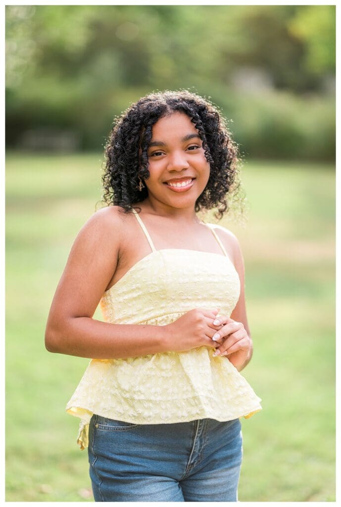 Natural light senior portrait at Acton Arboretum with soft green background.