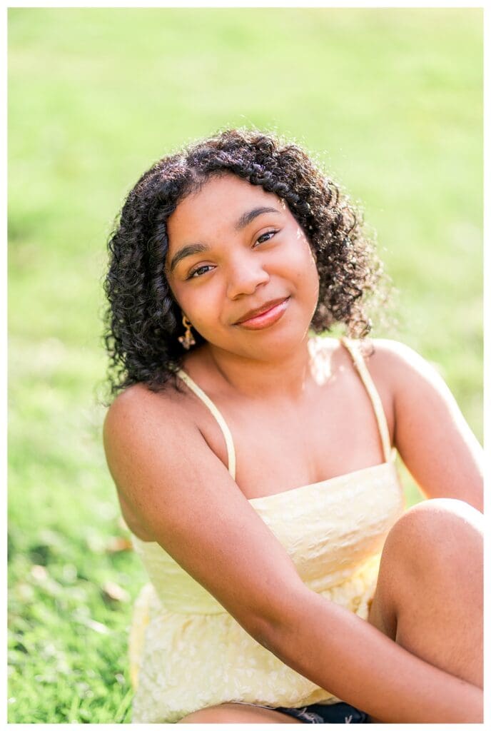 Soft light portrait of Massachusetts senior with loose curls and warm smile.