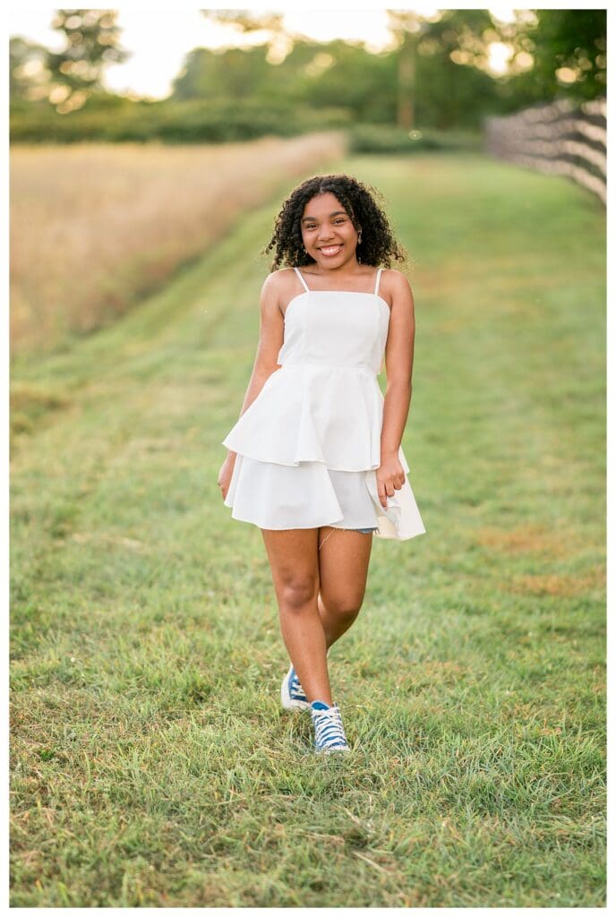 Candid walking shot of senior at Mattison Field during golden hour.