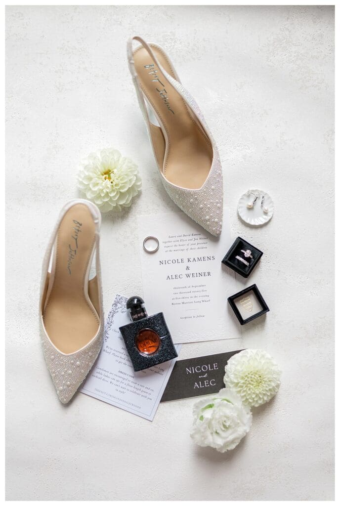Elegant wedding shoes with invitations in Boston Marriott hotel room.