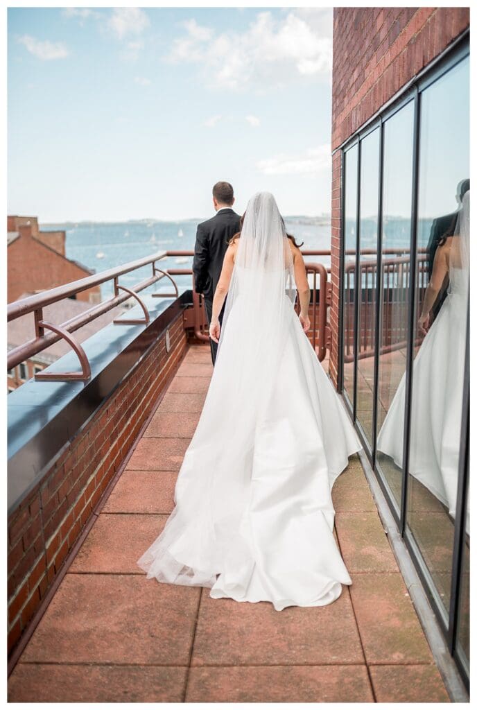 Bride tapping groom on shoulder during Boston hotel first look.