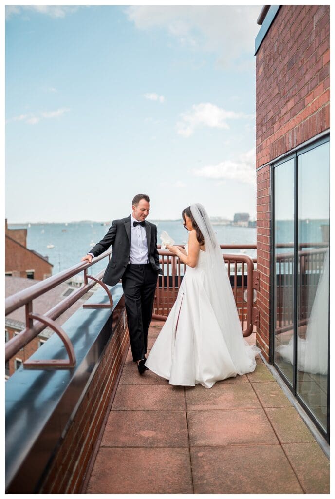 Bride and groom reading private vows overlooking Boston harbor.