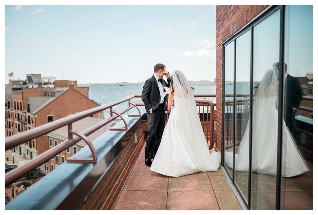 Groom wiping away tears during first look on balcony.