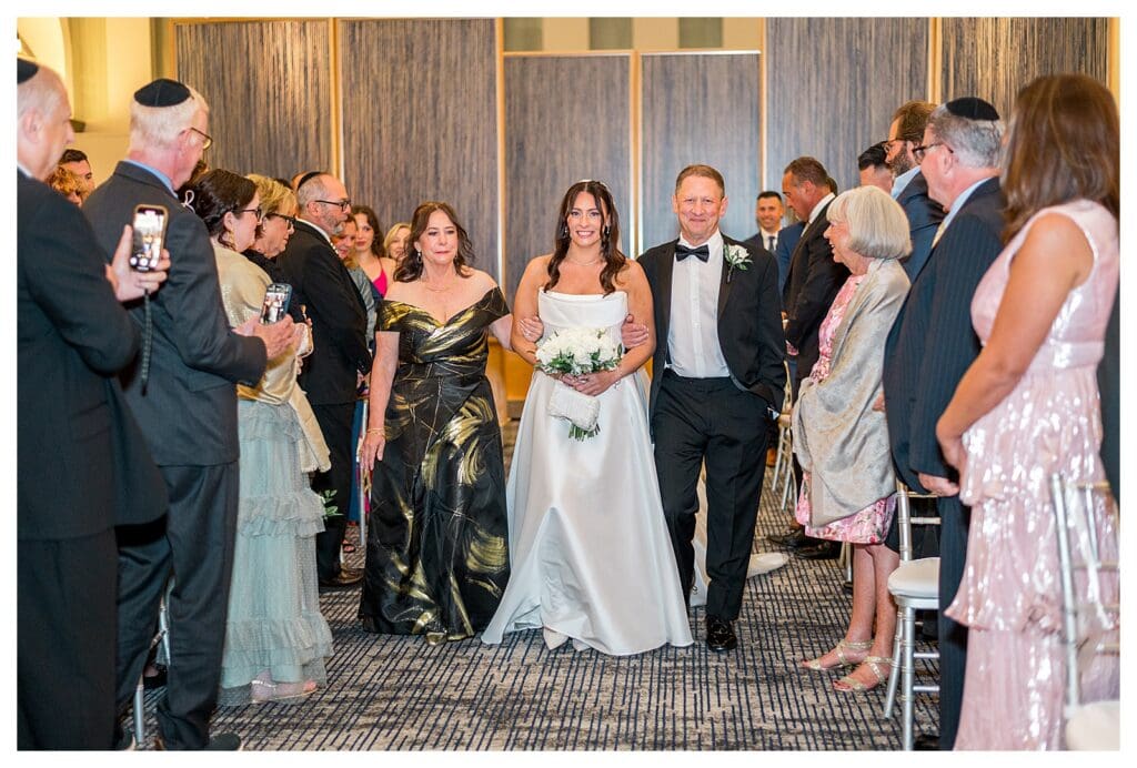 Bride walking down aisle at Boston harbor venue.