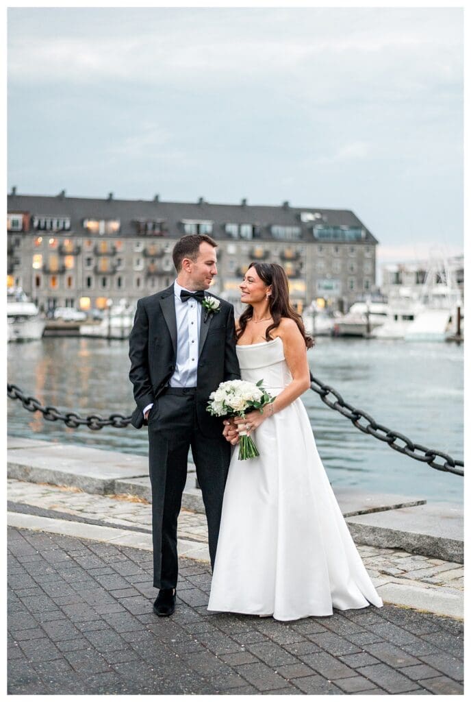 Couple smiling near boats during waterfront Boston Wedding.