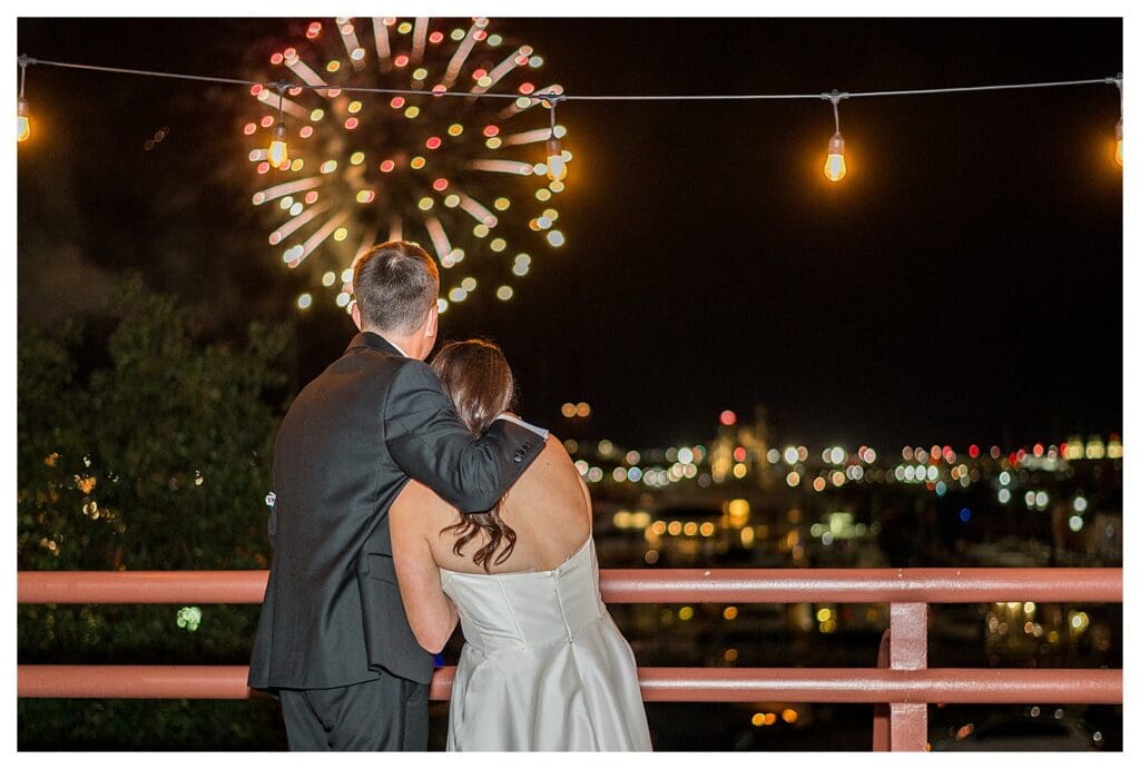 Boston Wedding Photographer capturing couple with fireworks over the harbor.