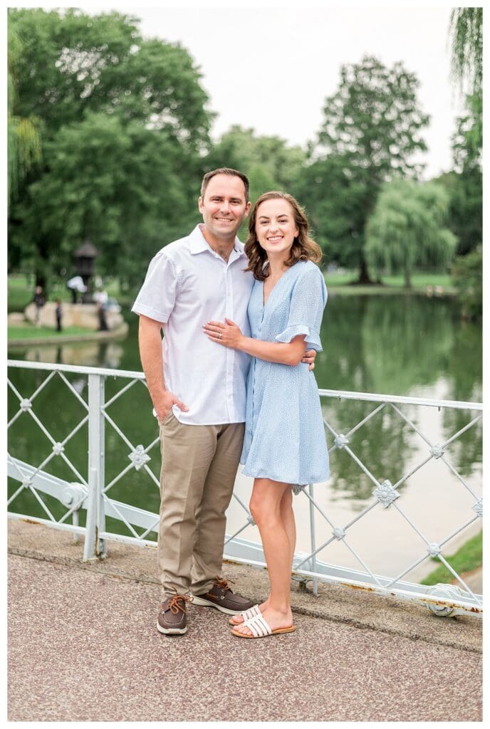 Couple standing on the bridge with water behind them in Boston Public Garden