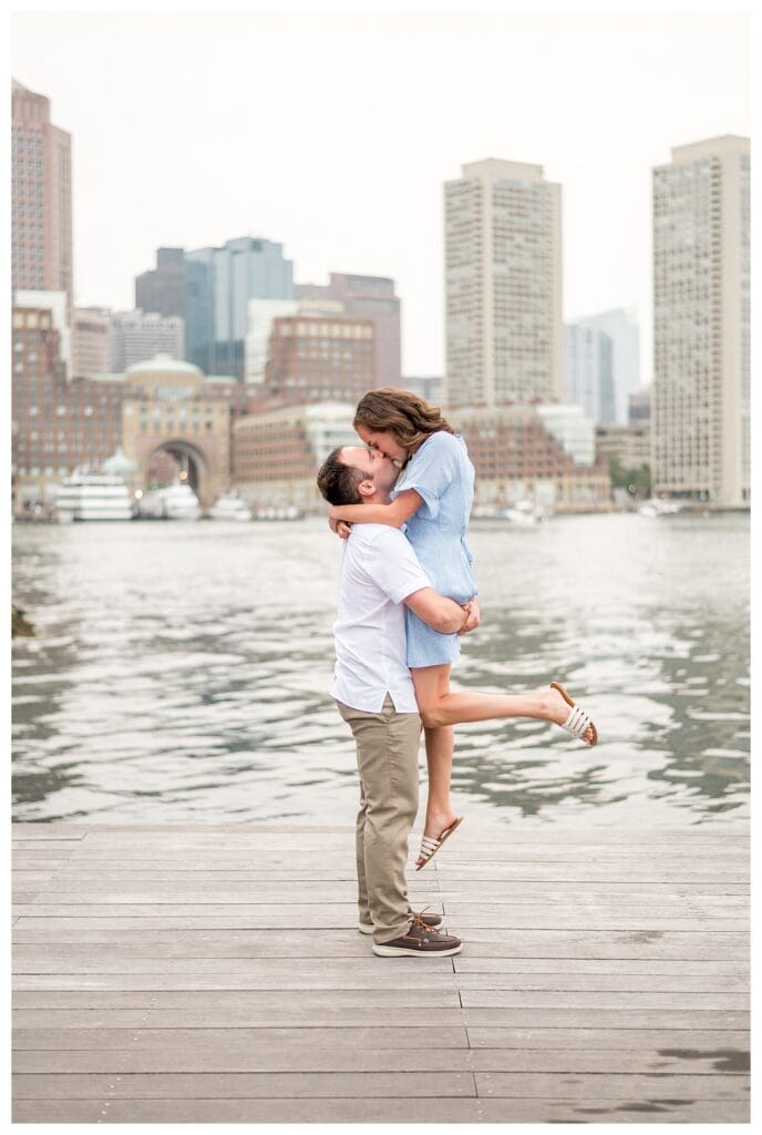Couple celebrating with lift and hug at Boston Seaport engagement session