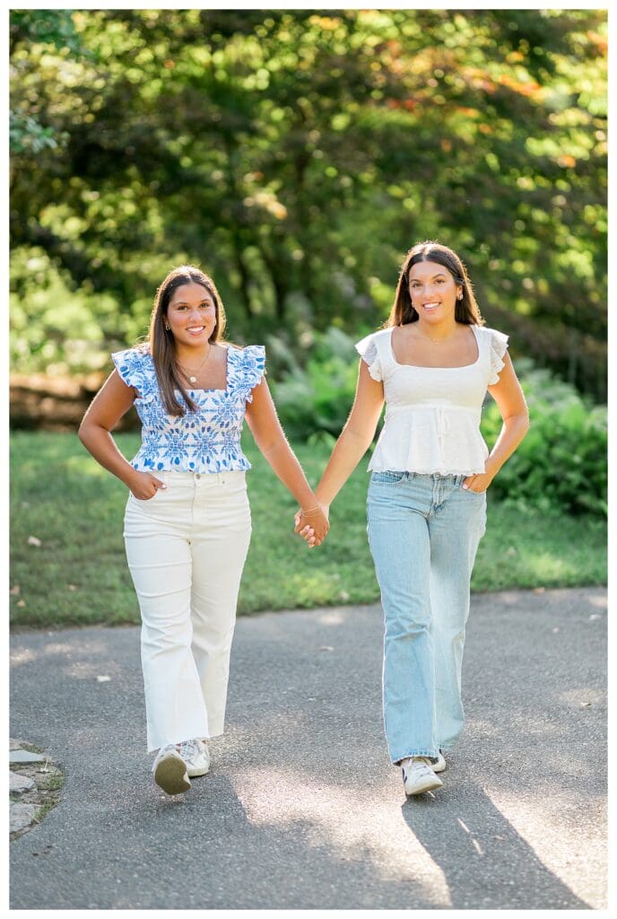 Twin sisters holding hands during senior photo session