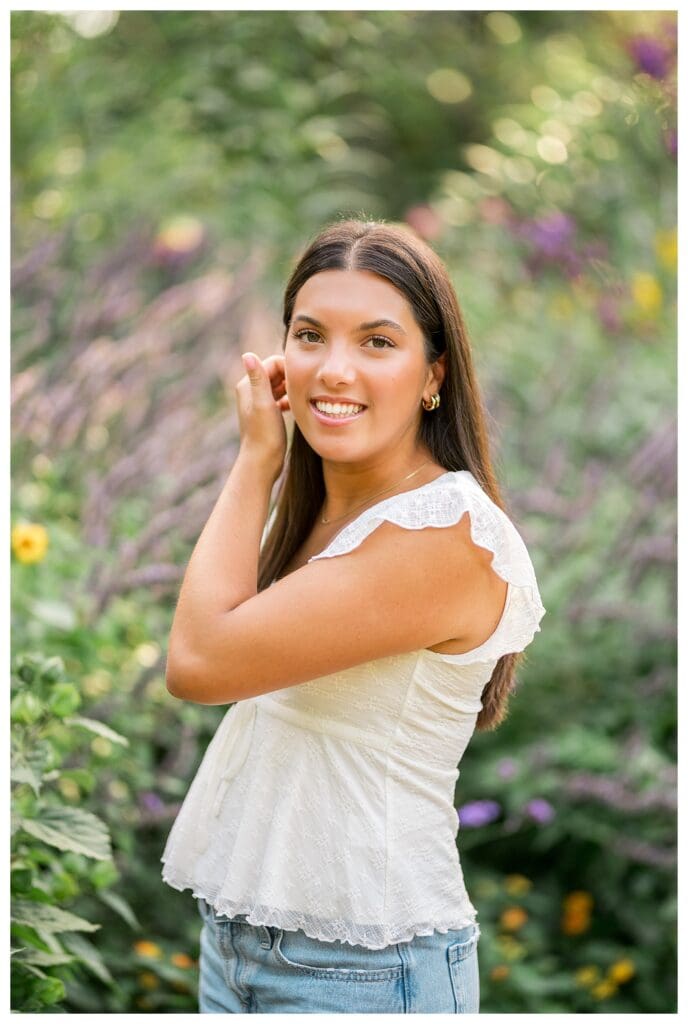 Dana Hall senior standing in floral garden at golden hour