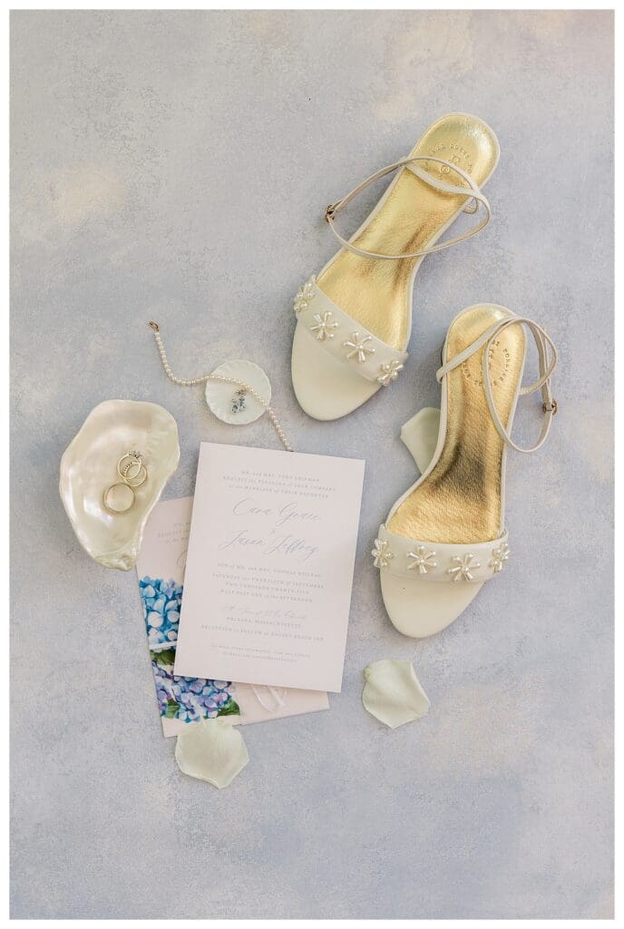 Wedding flat lay with shoes, jewelry, and coastal details