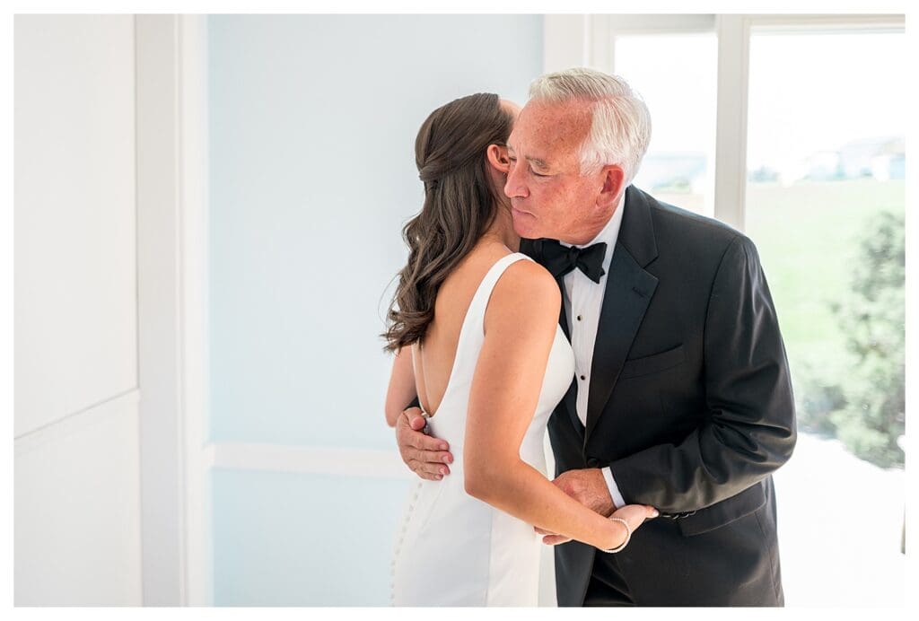 Bride hugging father before ceremony