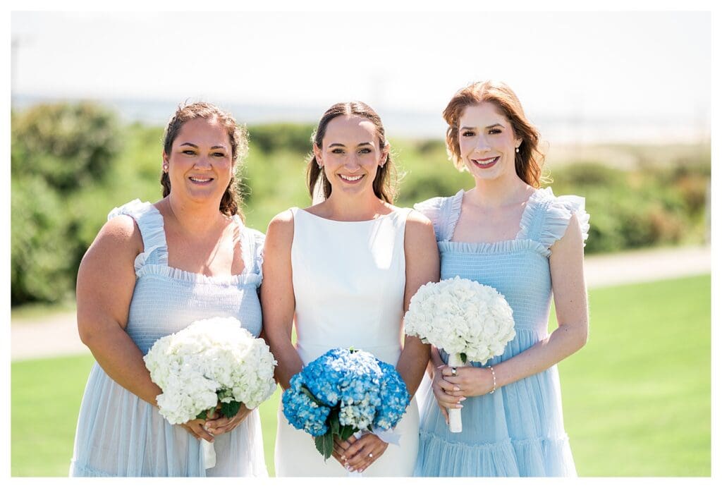Bridesmaids in light blue dresses holding hydrangeas