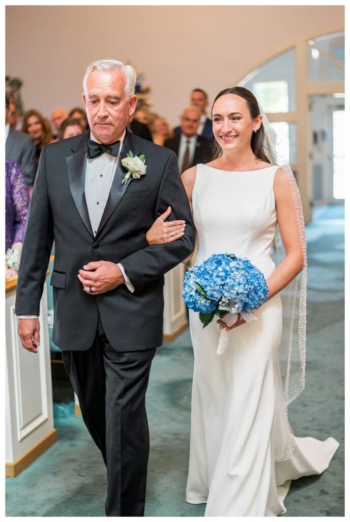 Bride walking down aisle with father in church