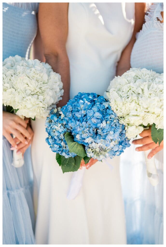 Bridesmaids holding blue and white bouquets