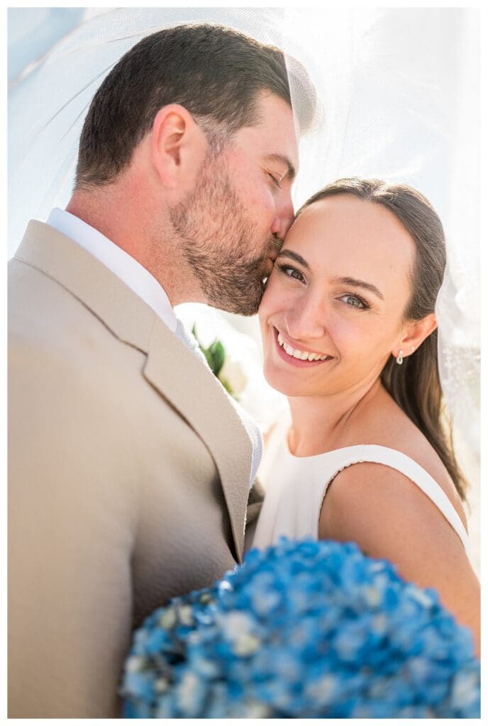 Romantic couple portrait with veil blowing in wind