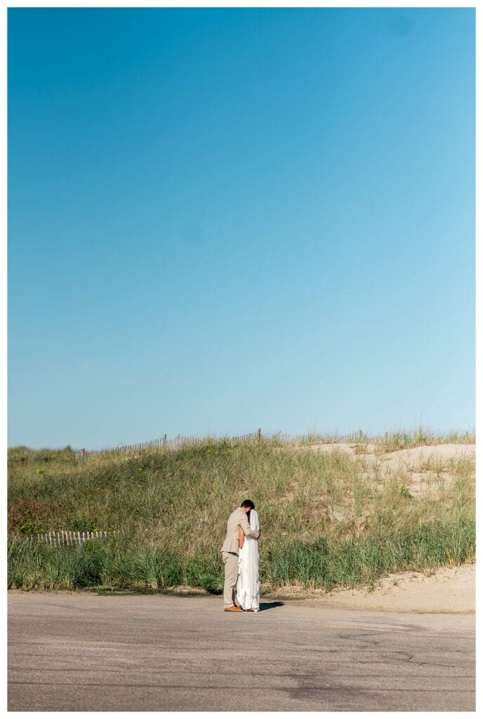 Couple embracing on beach dunes