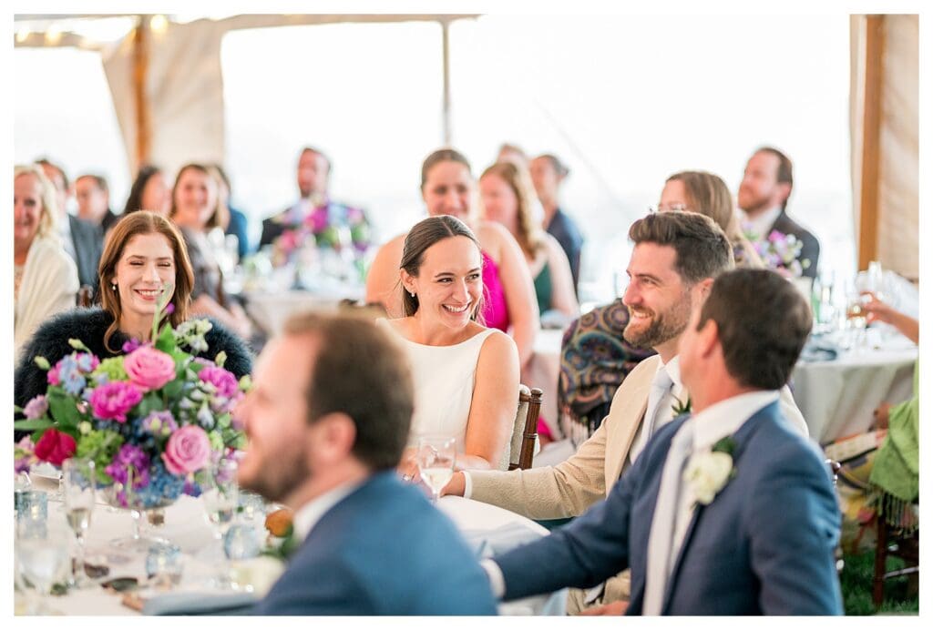 Bride and guests smiling and listening to speeches
