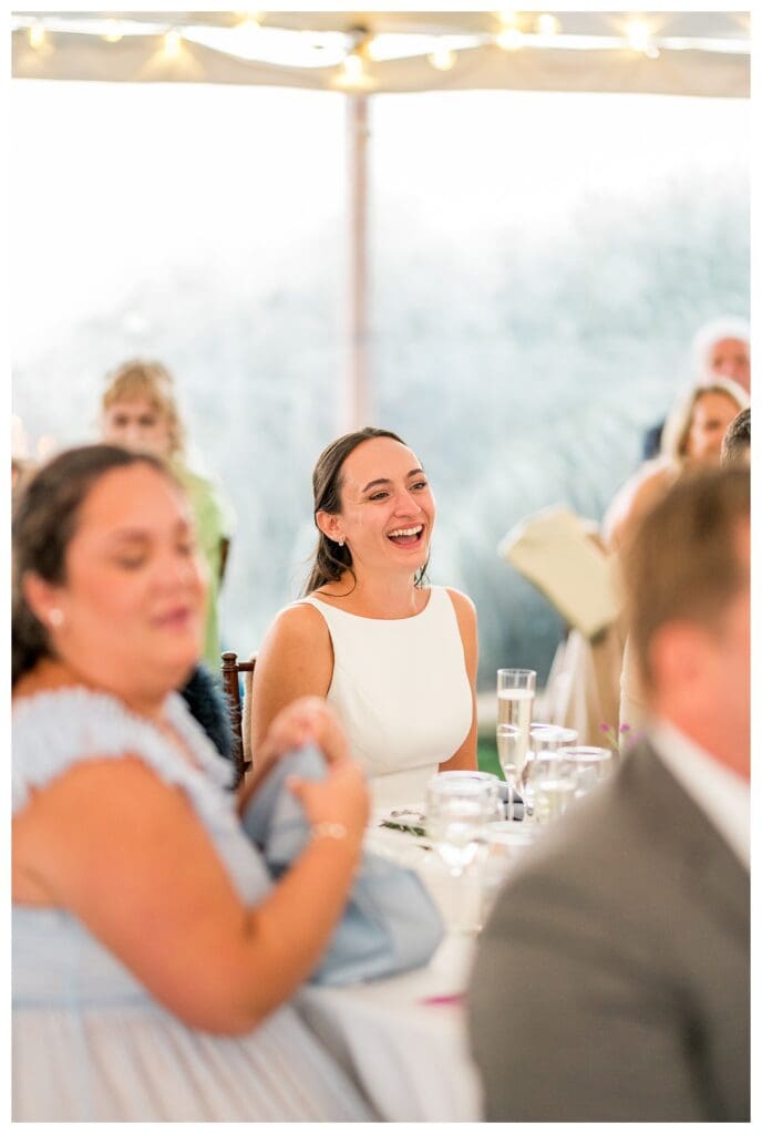 Bride laughing during reception toast