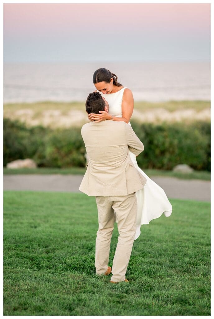 Groom lifting bride at sunset at Nauset Beach Inn Wedding