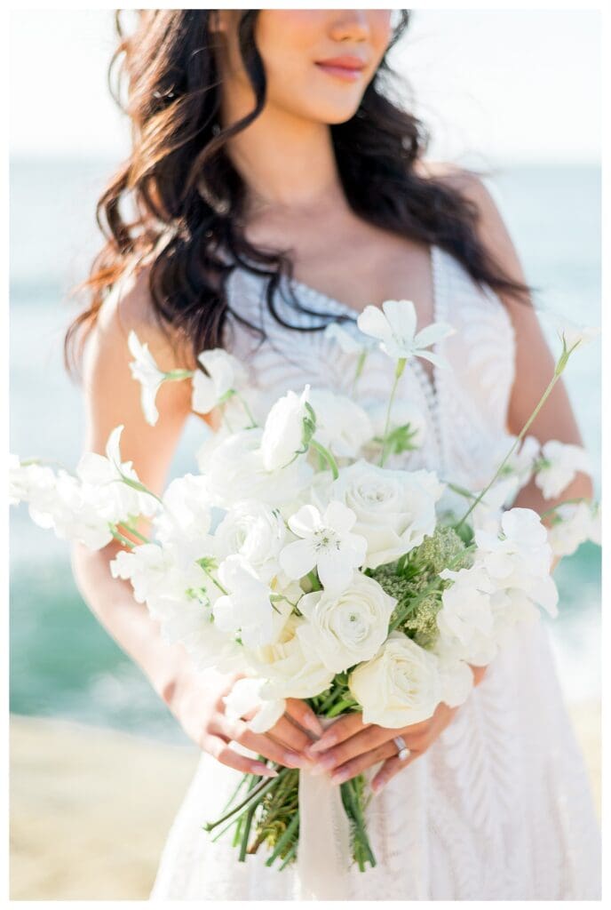 Bride holding large white bouquet with veil at Sunset Cliffs San Diego styled elopement shoot.