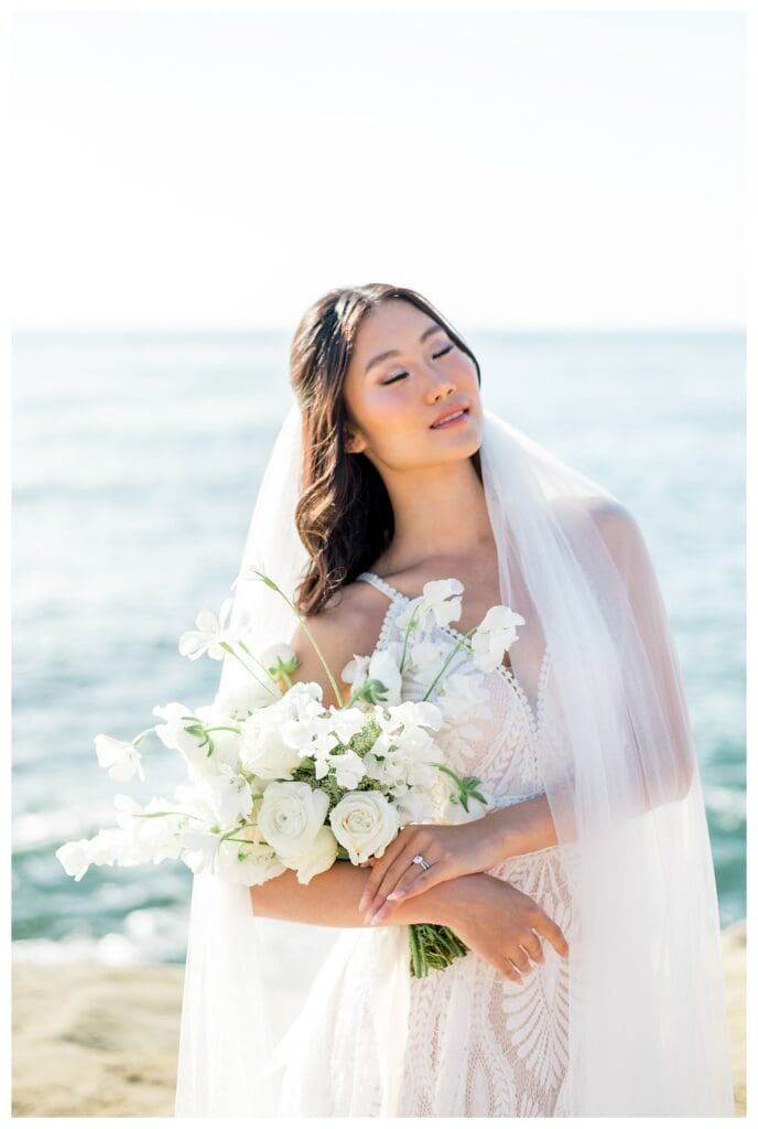 Bride in flowing white gown with veil at Sunset Cliffs San Diego styled elopement shoot.
