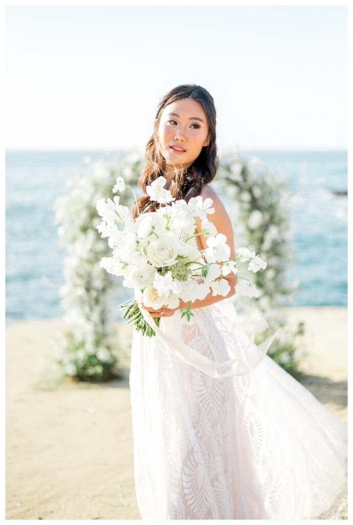 Bride with white floral bouquet at Sunset Cliffs San Diego styled elopement shoot.