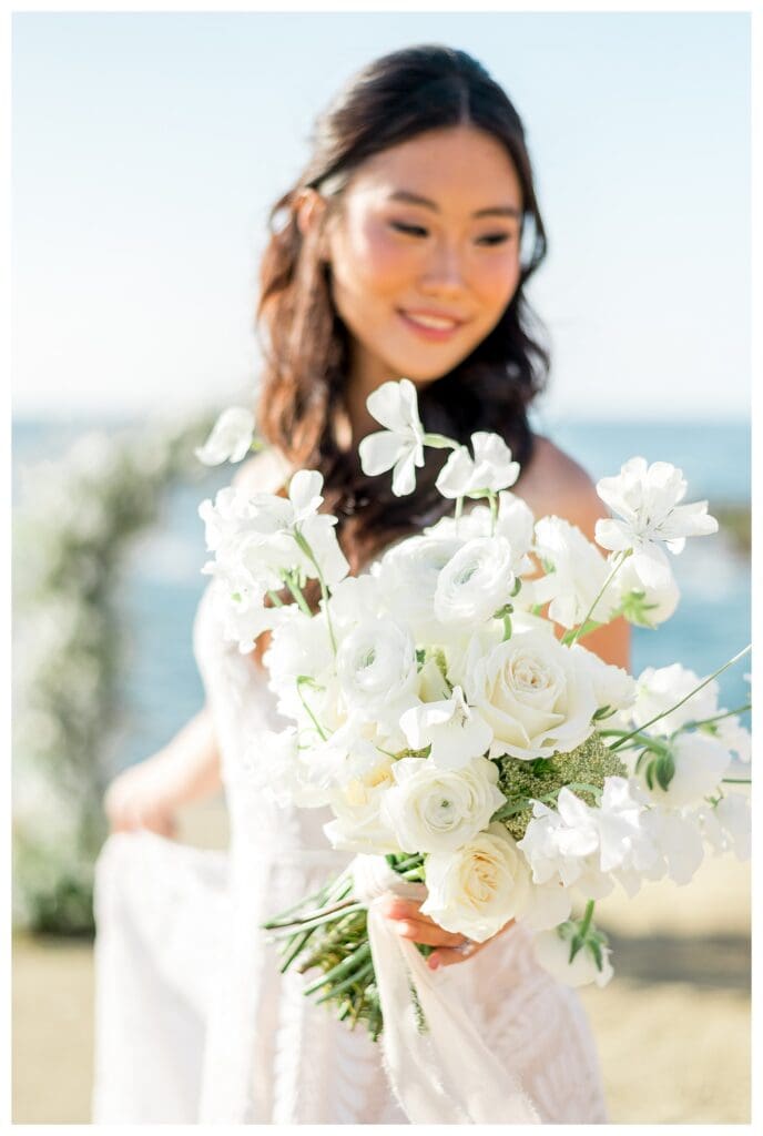 Bride holding large white bouquet at coastal San Diego elopement photography.

