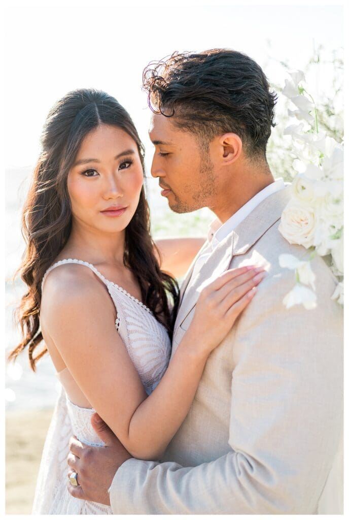 Groom kissing bride on the cheek at Sunset Cliffs San Diego styled elopement shoot.
