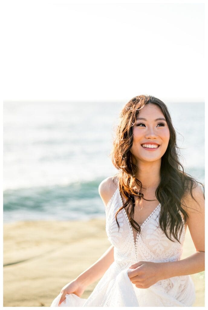 Bride smiling in white gown at Sunset Cliffs San Diego coastal elopement photography.
