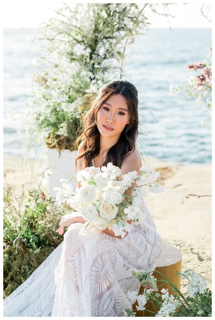 Bride with white bouquet seated outdoors at Sunset Cliffs San Diego elopement photography