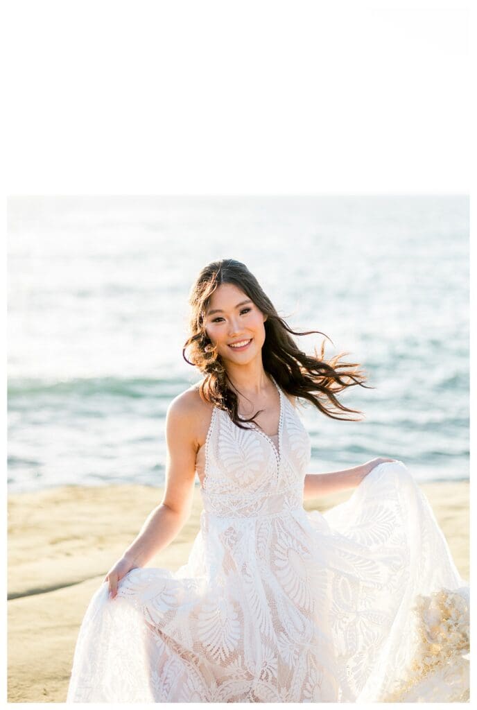 Bride in white dress with wind-blown hair at Sunset Cliffs San Diego elopement photographed by Sarah Surette Photography