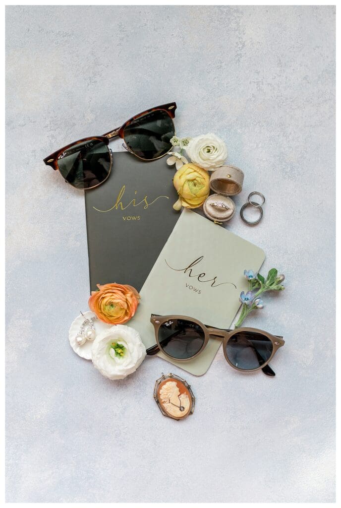 Bridal detail flat lay with sunglasses, florals, and invitation suite at Boston Harbor Hotel wedding