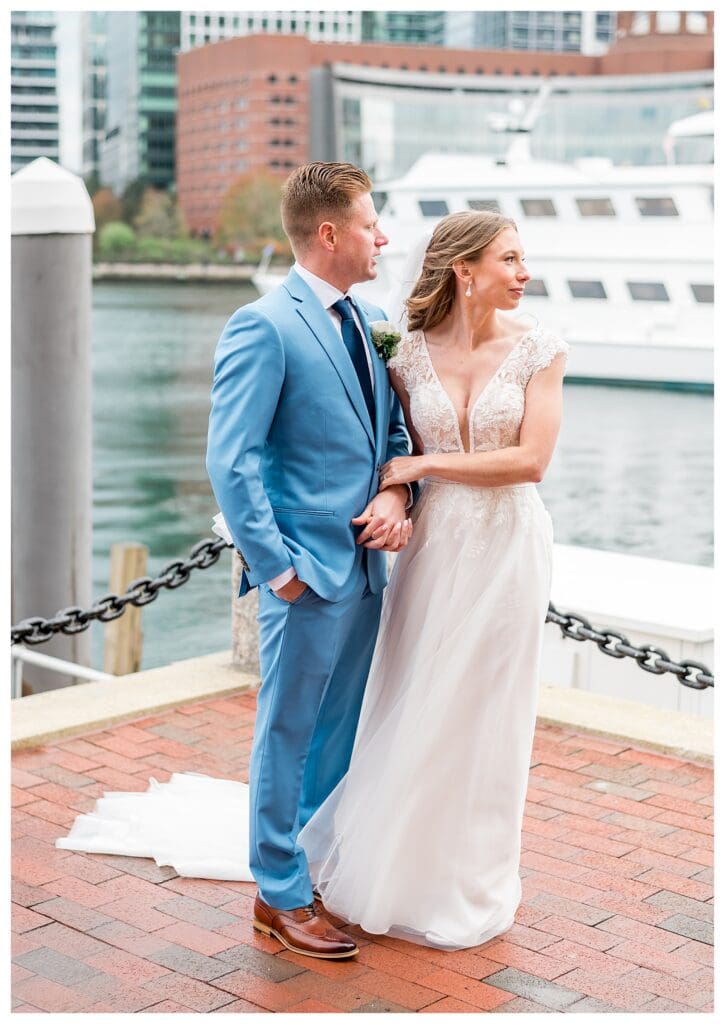 Bride and groom at the waterfront railing at Boston Harbor Hotel during portraits