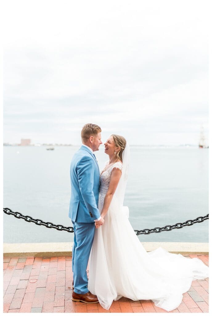 Bride and groom laughing together during portraits at Boston Harbor Hotel waterfront