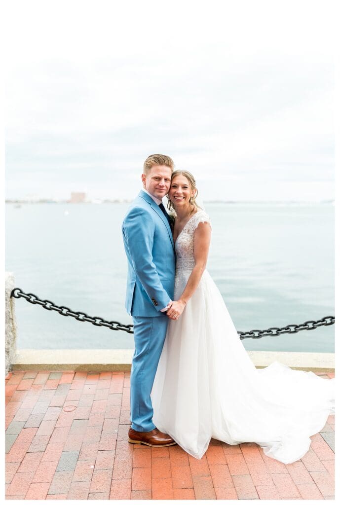 Bride and groom holding hands at Boston Harbor Hotel waterfront