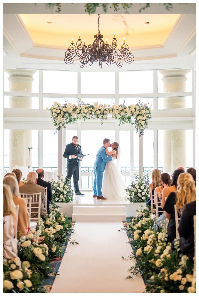 Bride and groom sharing first kiss during wedding ceremony at Boston Harbor Hotel
