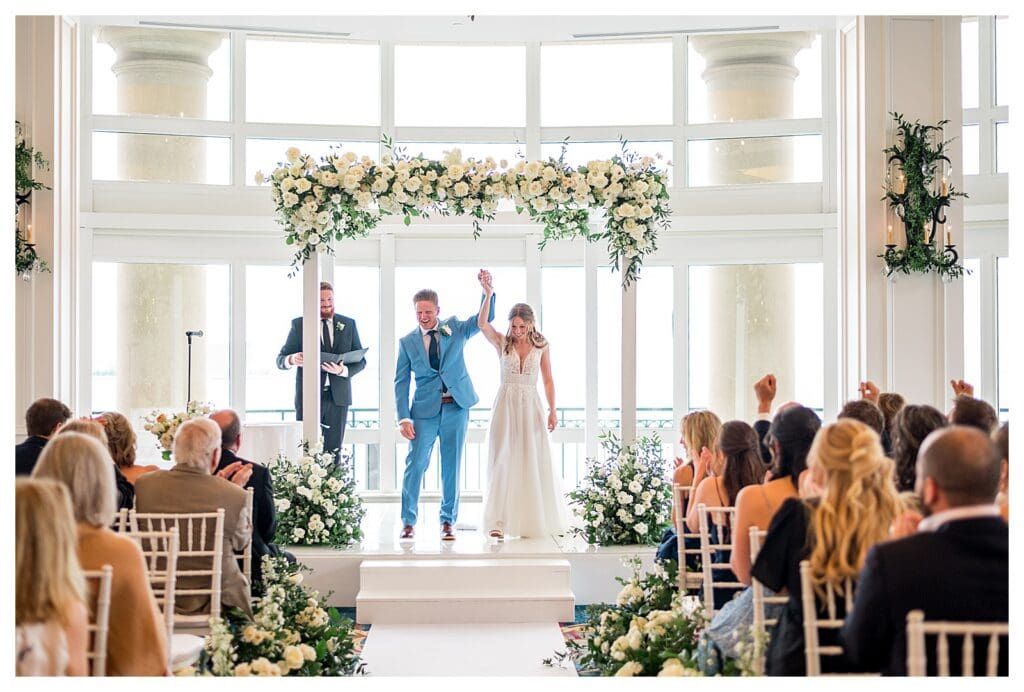Bride and groom standing under white chuppah during ceremony at Boston Harbor Hotel