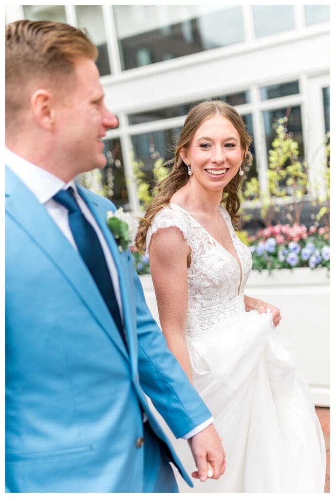 Bride walking toward Boston Harbor Hotel entrance on wedding day