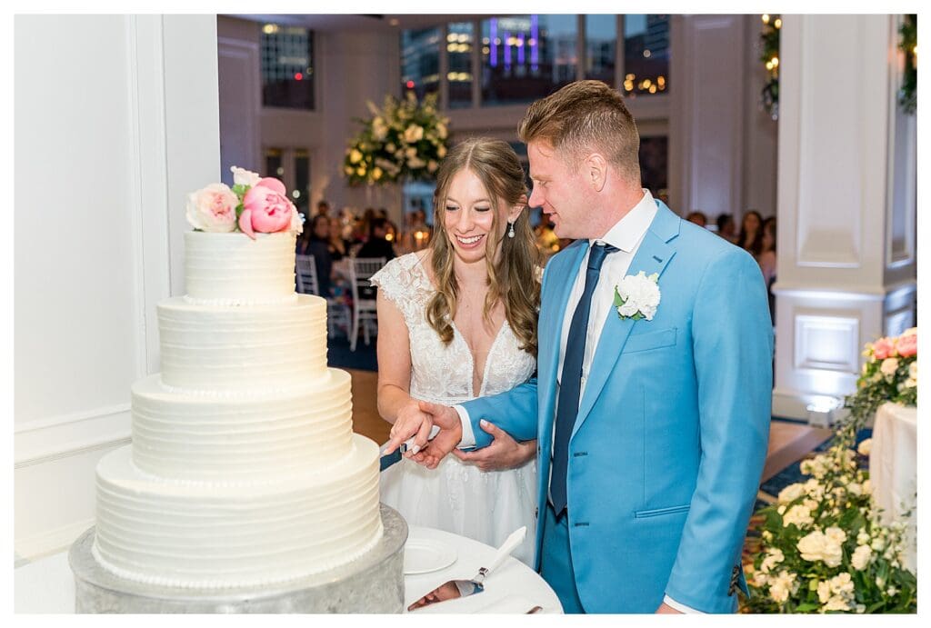 Bride and groom cutting wedding cake at Boston Harbor Hotel reception